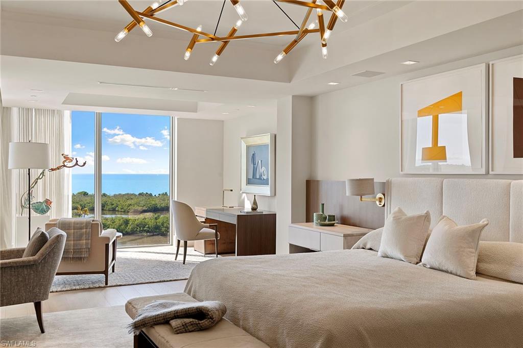 6897 Grenadier Boulevard, Unit 902 Naples, FL 34108 - Photo 23 of 50 a bedroom with a bed a large window with table and chairs