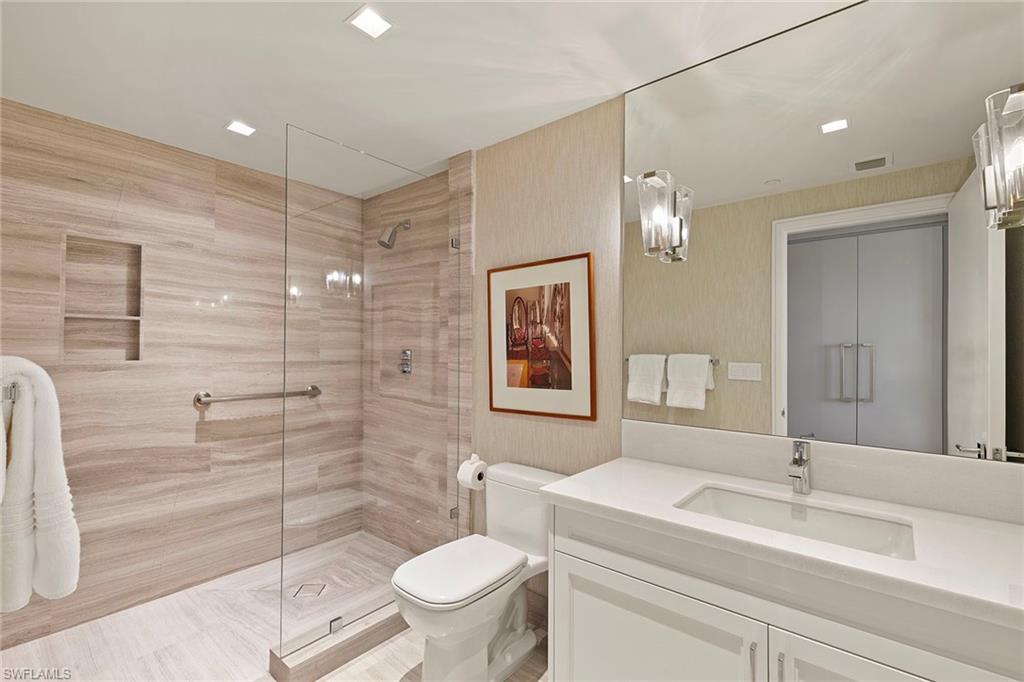 6897 Grenadier Boulevard, Unit 902 Naples, FL 34108 - Photo 35 of 50 a bathroom with a sink toilet vanity and shower