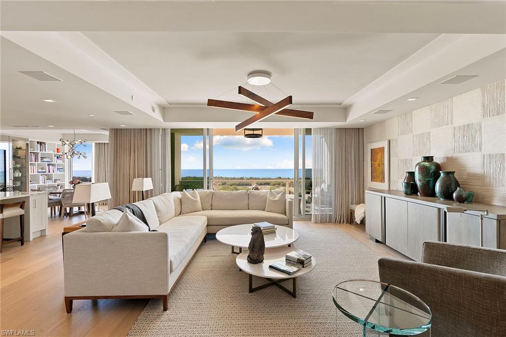 6897 Grenadier Boulevard, Unit 902 Naples, FL 34108 - Photo 5 of 50 a living room with furniture ceiling fan and a large window