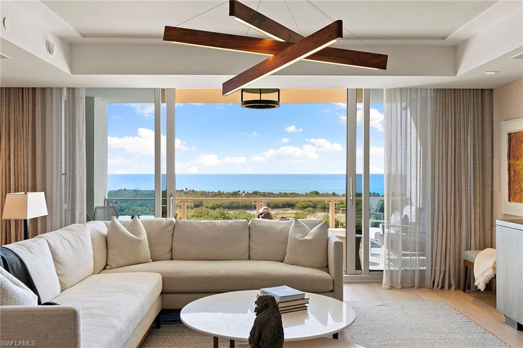 6897 Grenadier Boulevard, Unit 902 Naples, FL 34108 - Photo 6 of 50 a living room with furniture and a floor to ceiling window