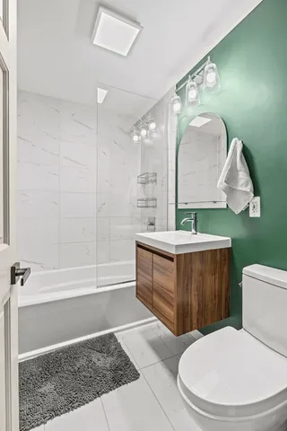 a bathroom with a sink a mirror a toilet and bathtub