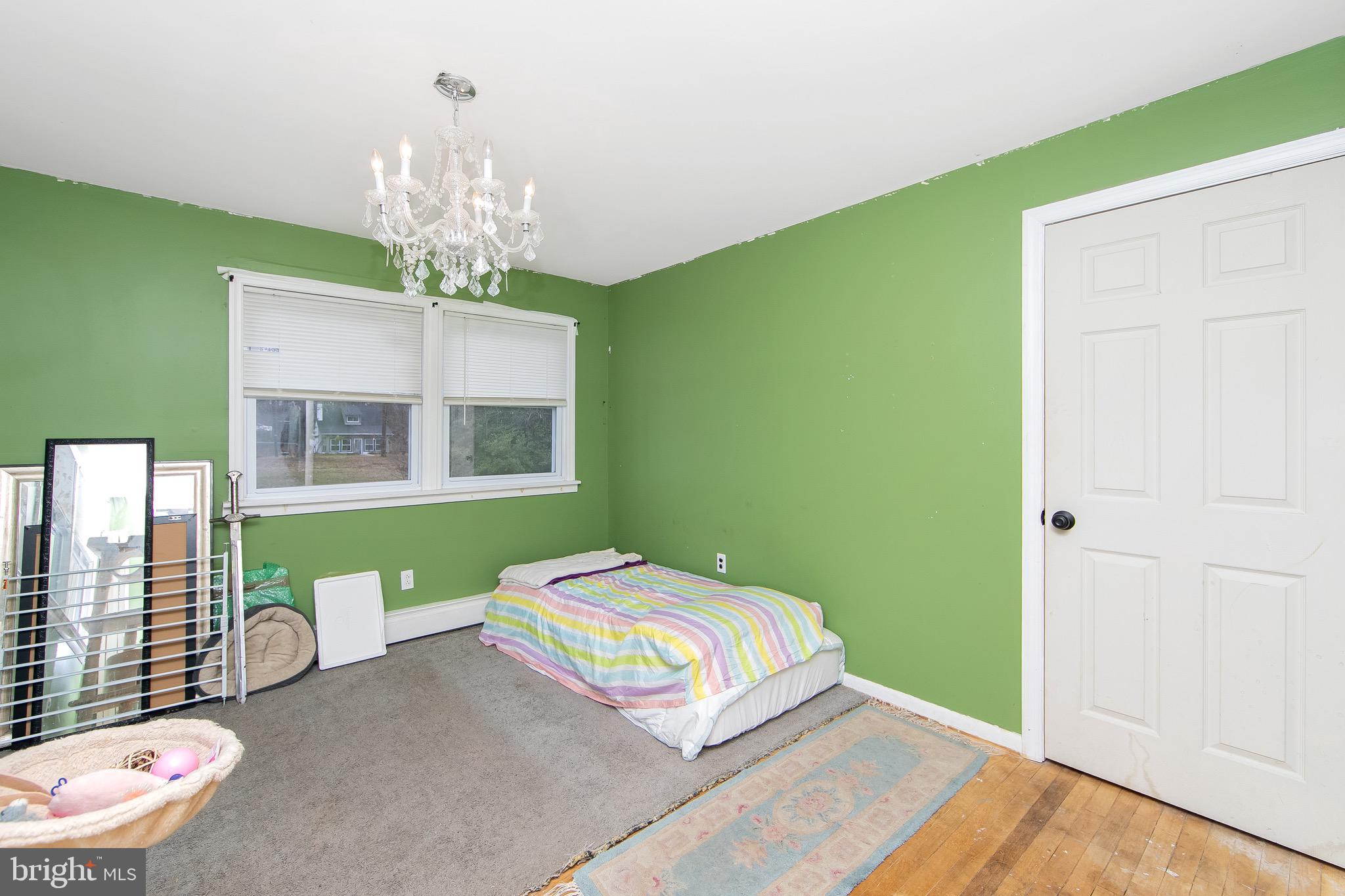 15 East Spring Street Pine Hill, NJ 08021 - Photo 18 of 38 a bedroom with a bed and a chandelier