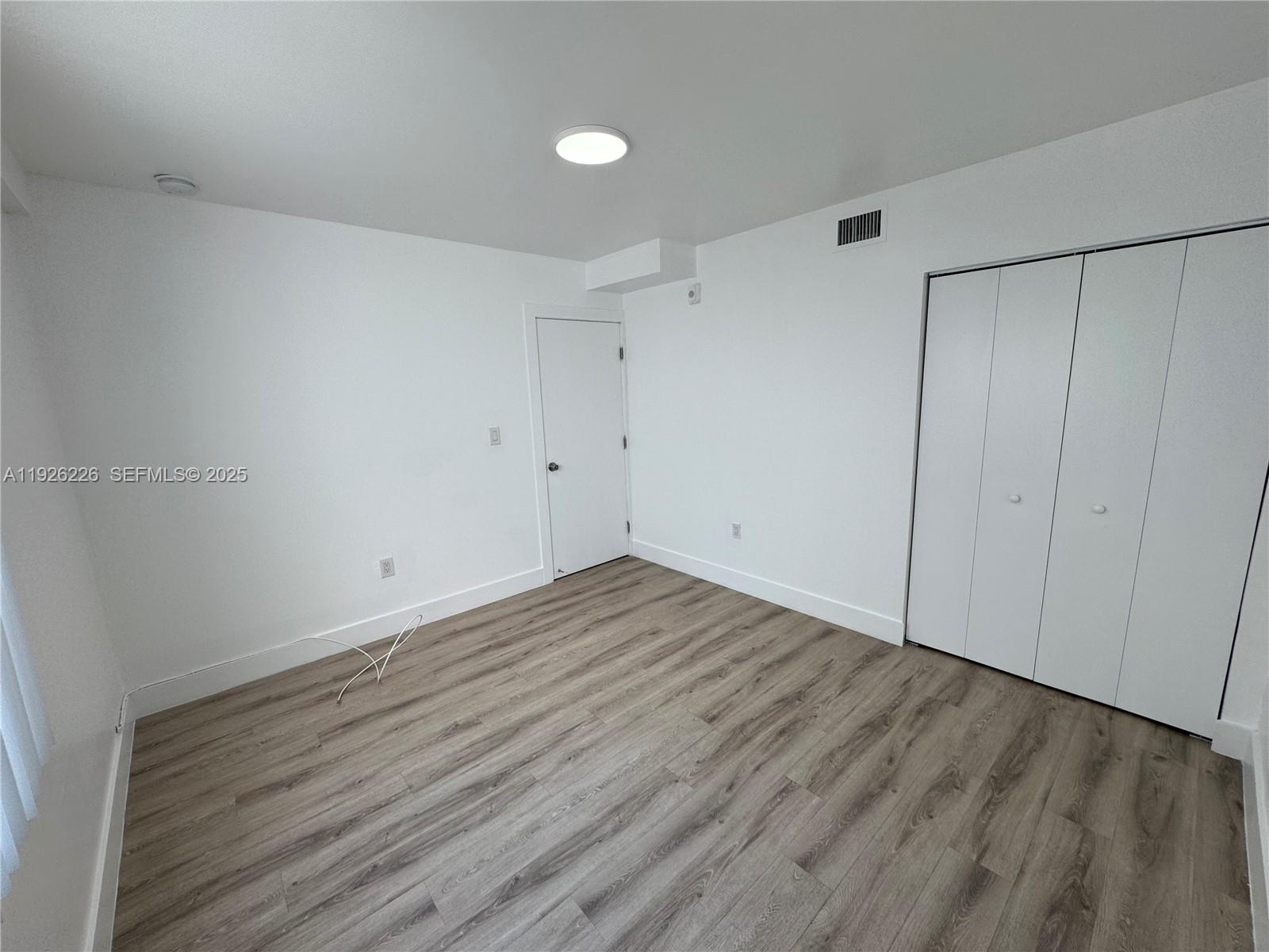 1969 Northwest 2nd Court, Unit 6 Miami, FL 33136 - Photo 14 of 17 a view of an empty room with wooden floor