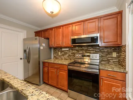 a kitchen with stainless steel appliances granite countertop a stove microwave refrigerator and sink
