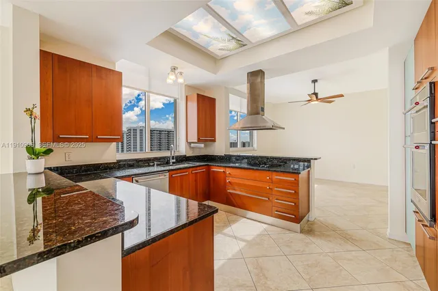 a living room with stainless steel appliances kitchen island granite countertop furniture and a large window