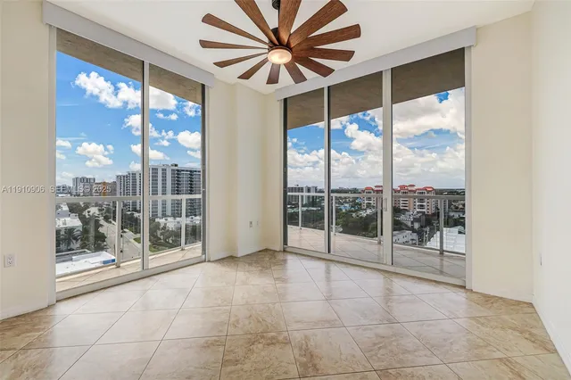 an empty room with a window and a ceiling fan