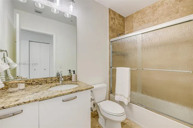 a living room with furniture a flat screen tv and white walls