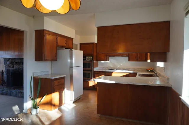 a kitchen with stainless steel appliances granite countertop a refrigerator a sink and a stove