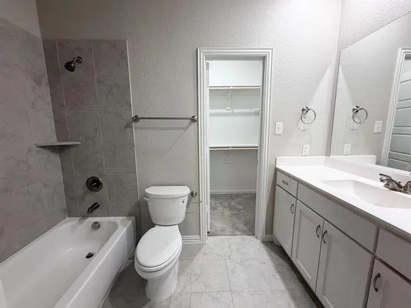 a bathroom with a granite countertop toilet a sink and a bathtub