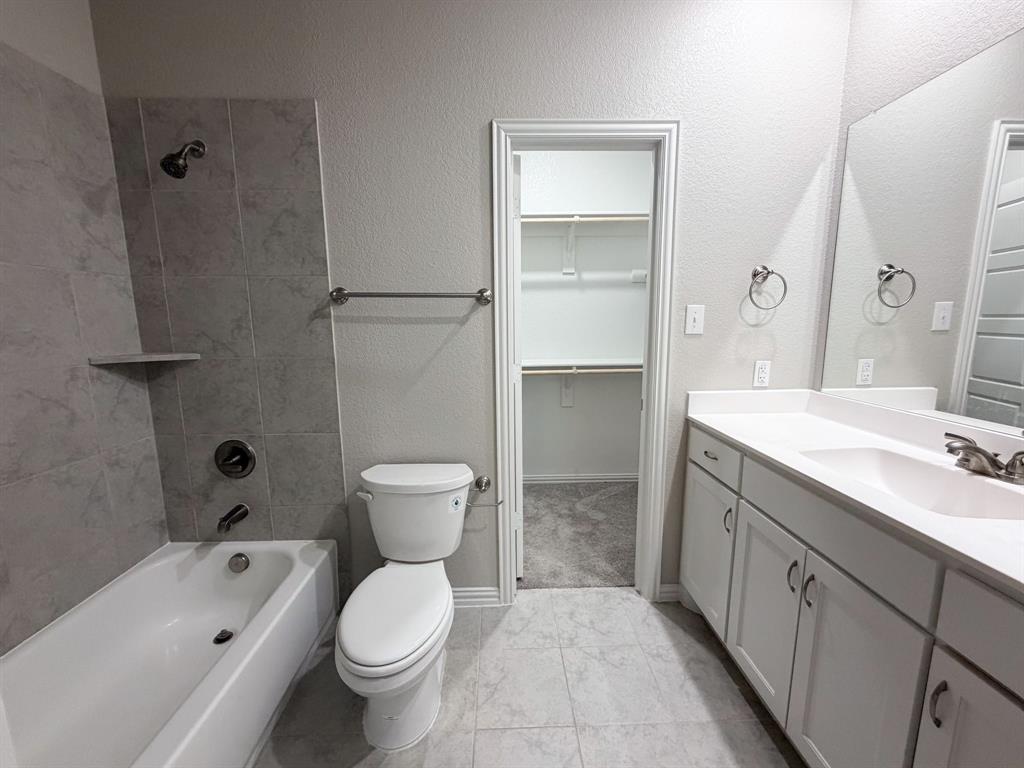 432 Restoration Road Waxahachie, TX 75165 - Photo 11 of 20 a bathroom with a granite countertop toilet a sink and a bathtub