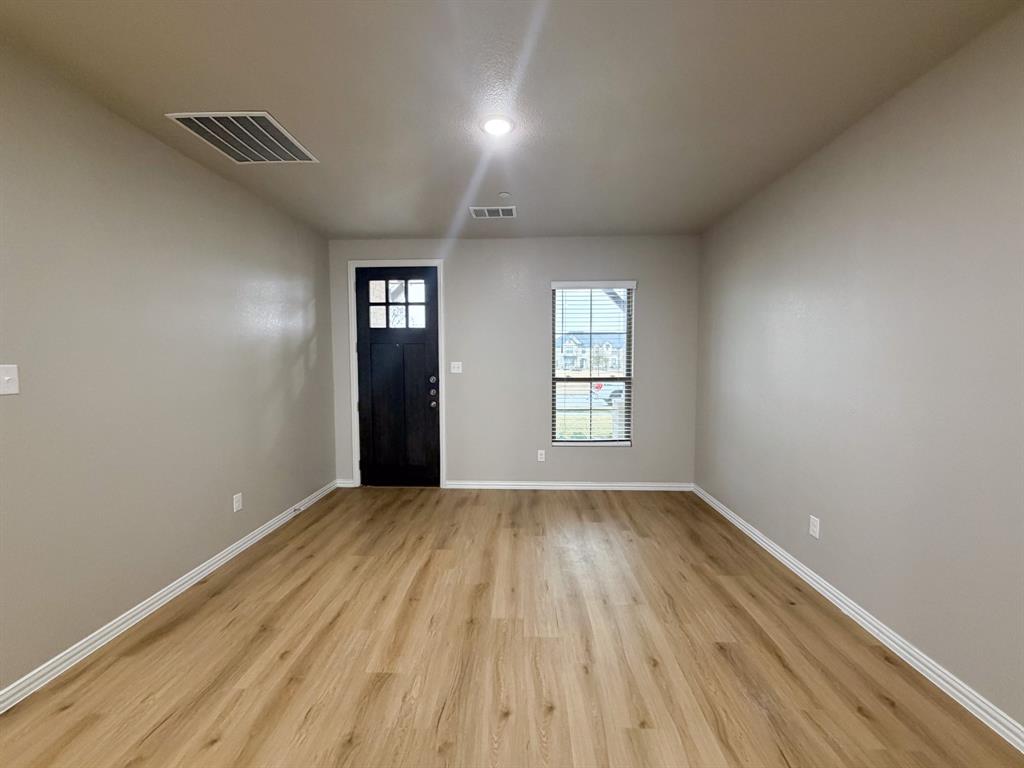 432 Restoration Road Waxahachie, TX 75165 - Photo 13 of 20 an empty room with wooden floor and windows