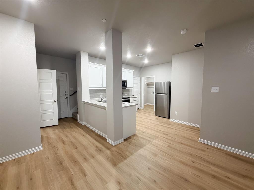 432 Restoration Road Waxahachie, TX 75165 - Photo 4 of 20 an empty room with wooden floor and windows