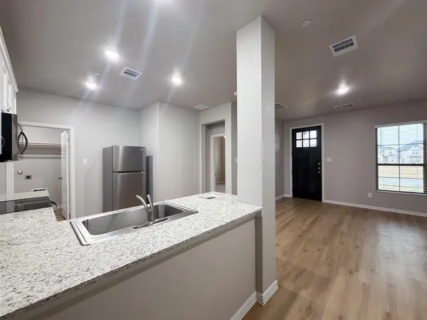 a bathroom with a granite countertop sink and a large mirror