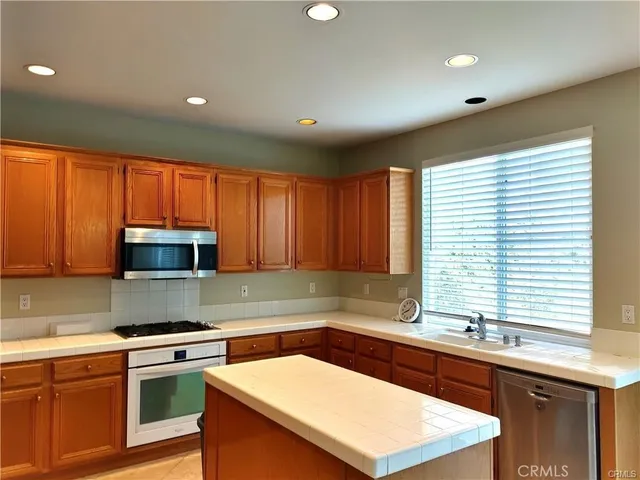a kitchen with a sink a stove cabinets and wooden floor