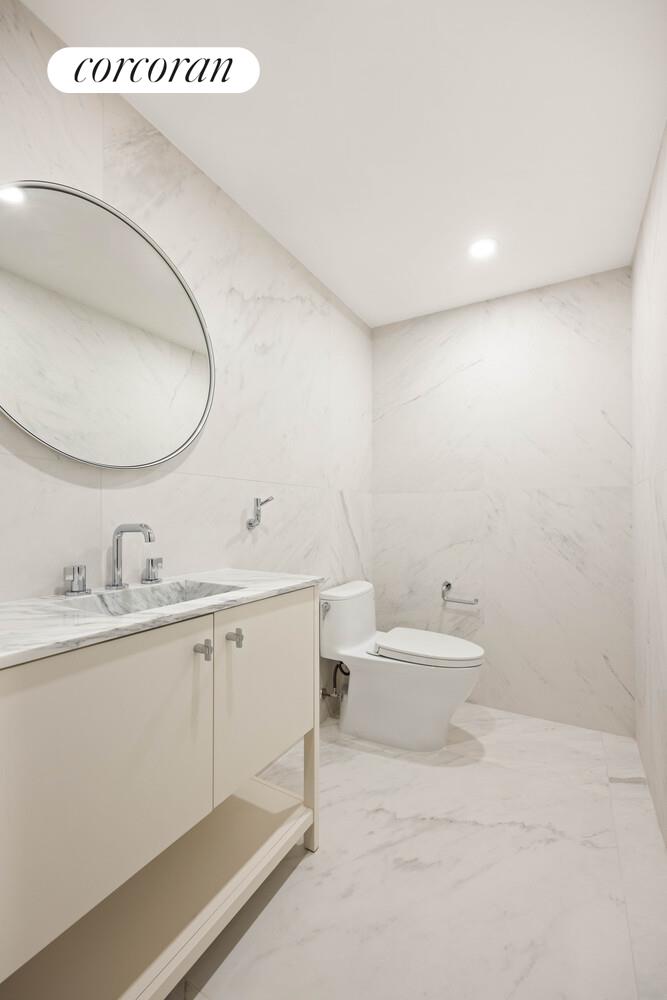 292 Gates Avenue Brooklyn, NY 11216 - Photo 17 of 25 a bathroom with a granite countertop sink and a mirror