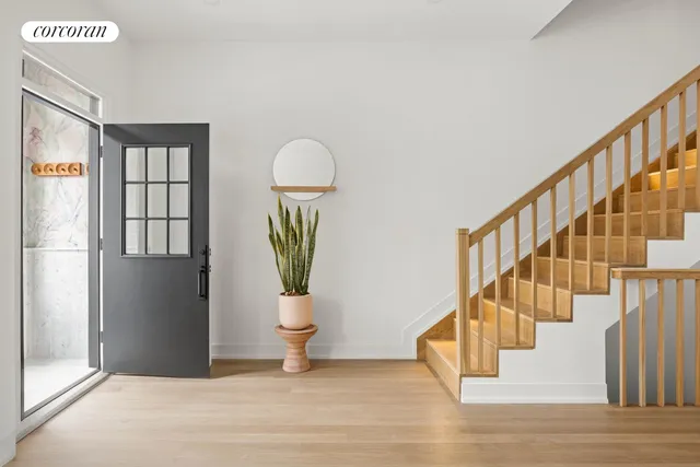 a view of entryway and hall with wooden floor