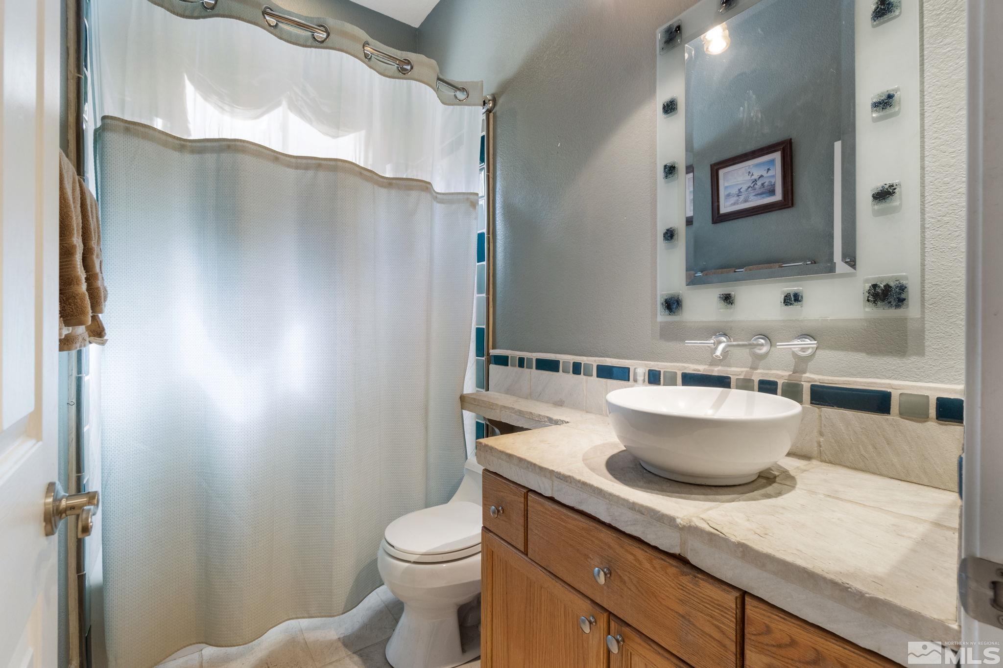 9607 Glen Ridge Drive Reno, NV 89521 - Photo 18 of 22 a bathroom with a granite countertop sink and a toilet