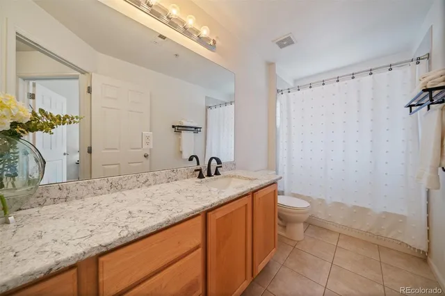 a bathroom with a granite countertop sink toilet and shower