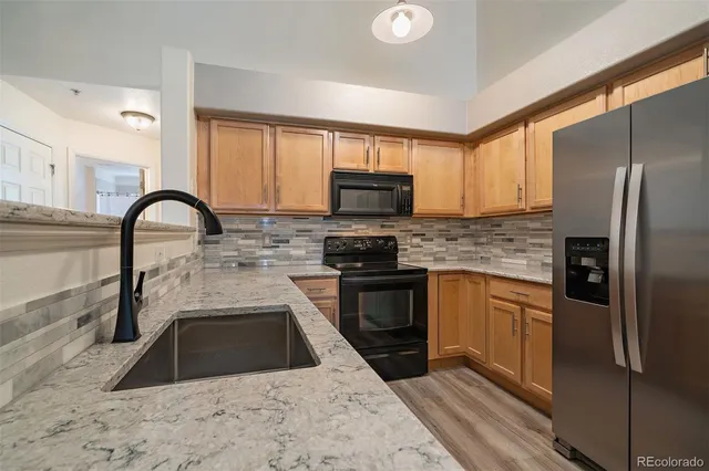 a kitchen with a refrigerator sink and wooden cabinets