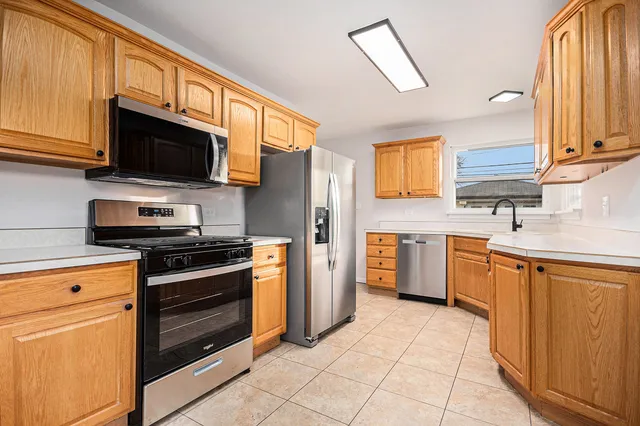 a kitchen with stainless steel appliances granite countertop a stove microwave refrigerator sink and cabinets