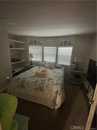 a bed sitting in a bedroom next to a window