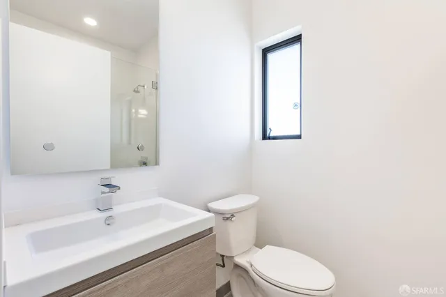 a bathroom with a sink a toilet and mirror