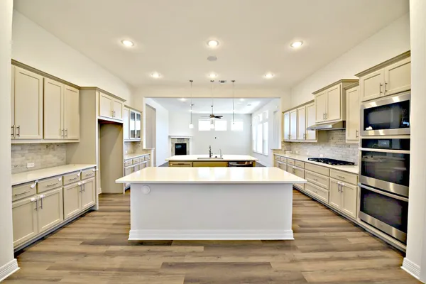 a large kitchen with stainless steel appliances kitchen island granite countertop a stove and a sink