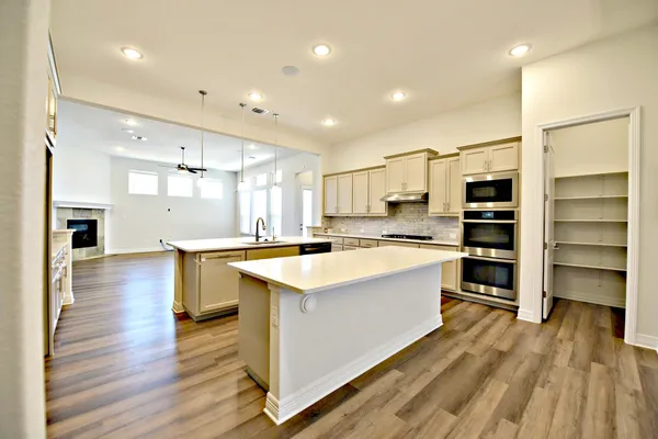 a large kitchen with kitchen island a sink a stove and a refrigerator