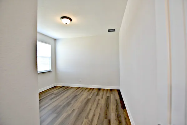 a view of room with window and wooden floor