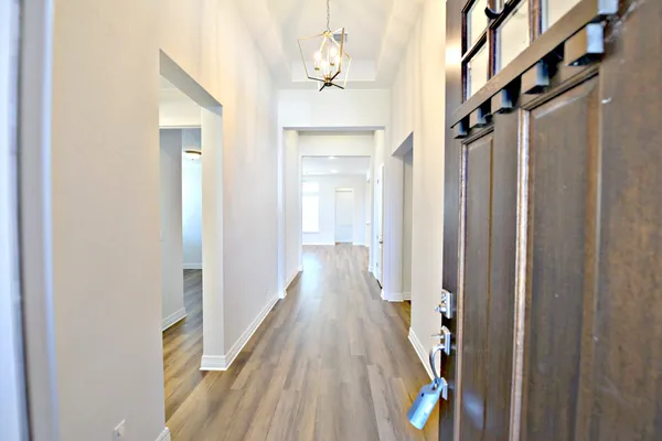 a view of hallway with wooden floor and stairs