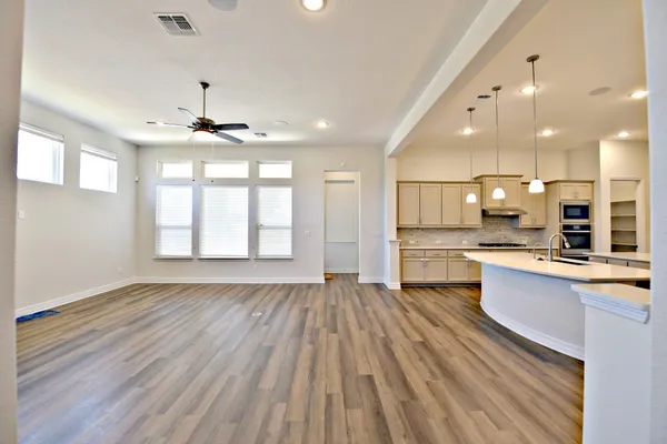 a large kitchen with stainless steel appliances granite countertop a lot of counter space and wooden floors