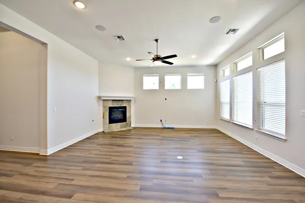 a view of an empty room with window and wooden floor