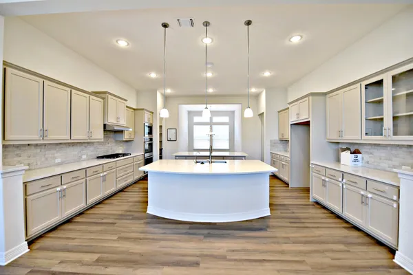 a large kitchen with stainless steel appliances granite countertop a large center island and a sink