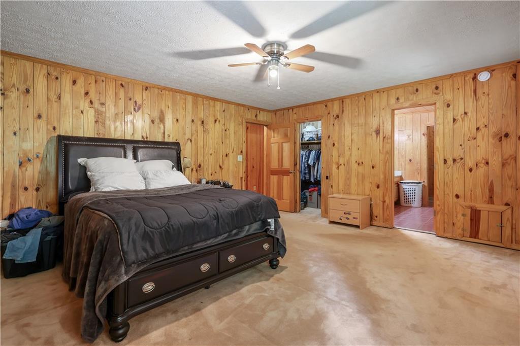 7505 Hall Road Fairburn, GA 30213 - Photo 25 of 43 a spacious bedroom with a bed and a chandelier