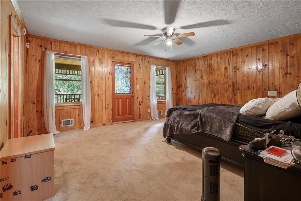 7505 Hall Road Fairburn, GA 30213 - Photo 26 of 43 a bedroom with a bed and glass walk in closet