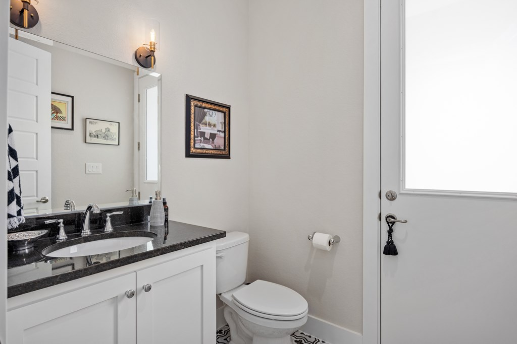 2085 Toscano Way Kerrville, TX 78028 - Photo 18 of 36 a bathroom with a granite countertop sink mirror vanity and toilet