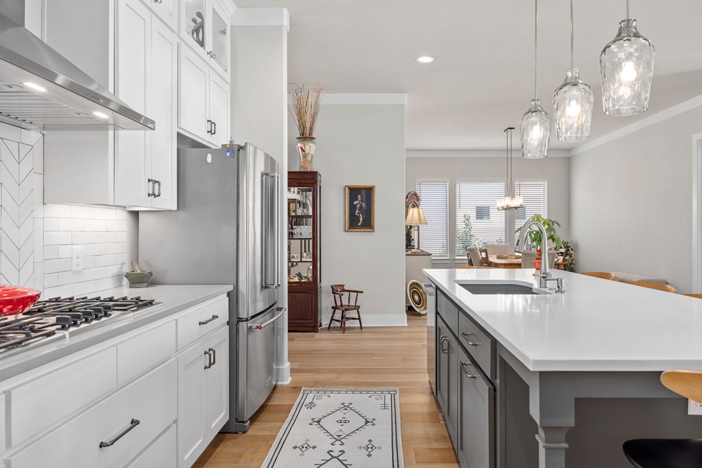 2085 Toscano Way Kerrville, TX 78028 - Photo 9 of 36 a kitchen with stainless steel appliances a stove a sink dishwasher and a refrigerator with wooden floor