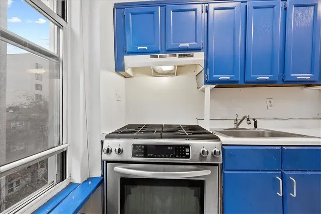 a kitchen with wooden cabinets stove top oven and sink