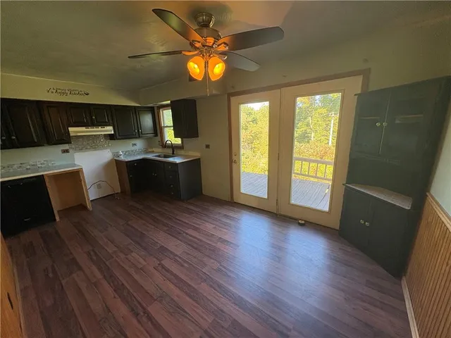 a living room with stainless steel appliances wooden floors and wooden floors