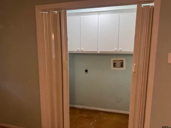 an empty room with a windows and a chandelier fan