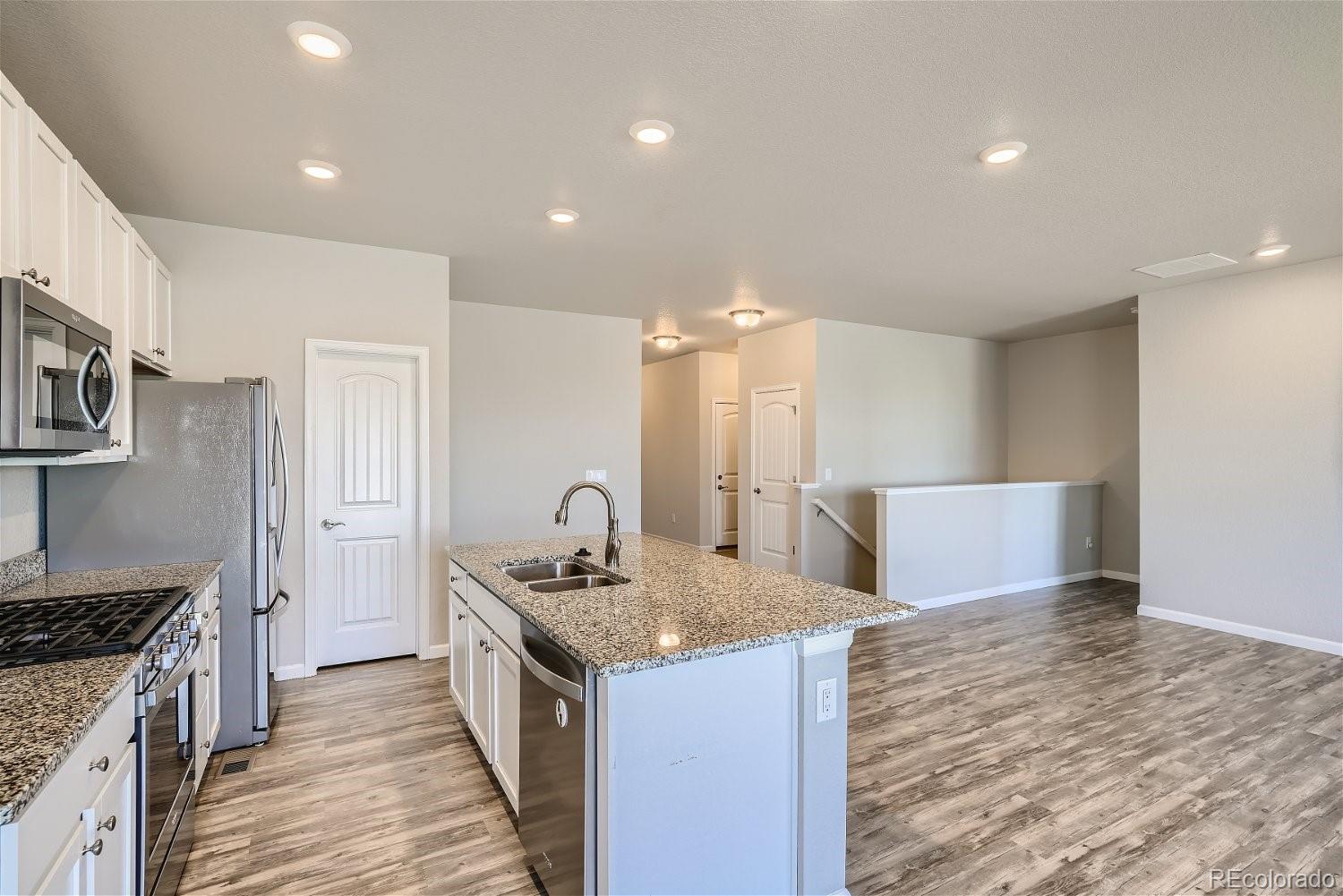 4718 River Highlands Loop Elizabeth, CO 80107 - Photo 11 of 28 a kitchen with stainless steel appliances granite countertop a sink stove and refrigerator