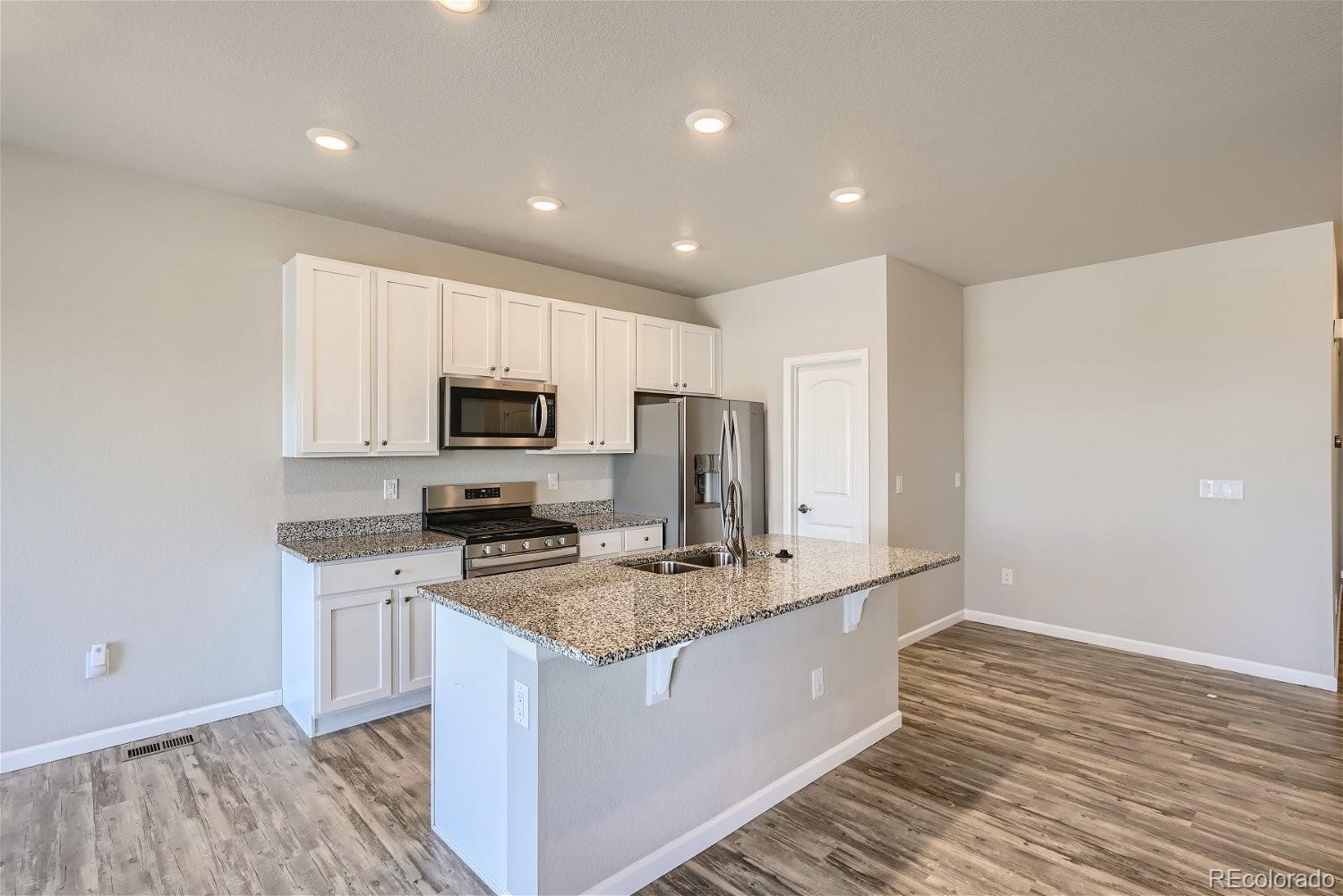 4718 River Highlands Loop Elizabeth, CO 80107 - Photo 10 of 28 a kitchen with stainless steel appliances granite countertop a sink stove and refrigerator