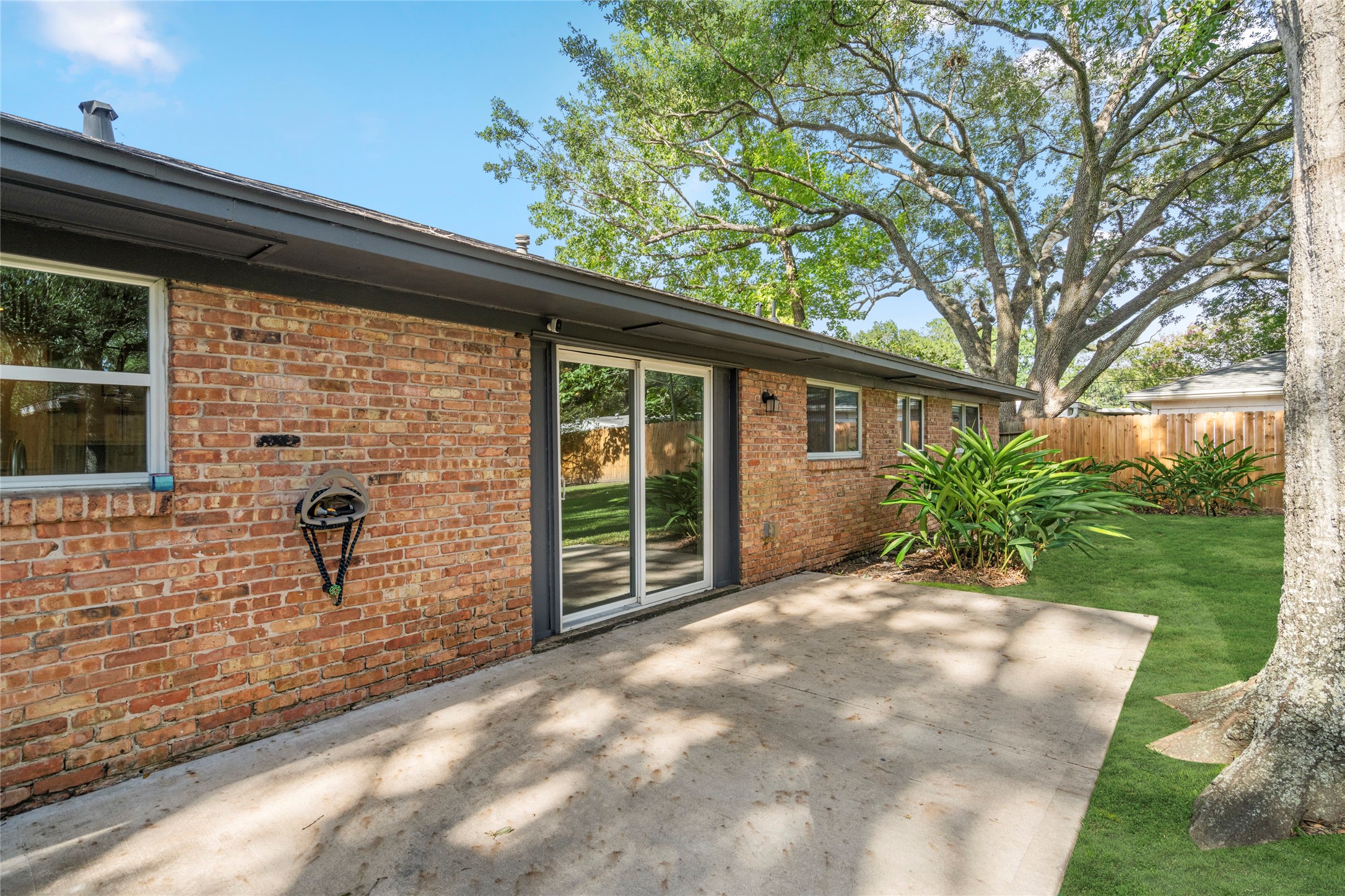 5723 Spellman Road Houston, TX 77096 - Photo 27 of 29 The patio sits just outside the kitchen and dining area, making it a convenient spot for grilling, outdoor dining, or relaxing under the trees.