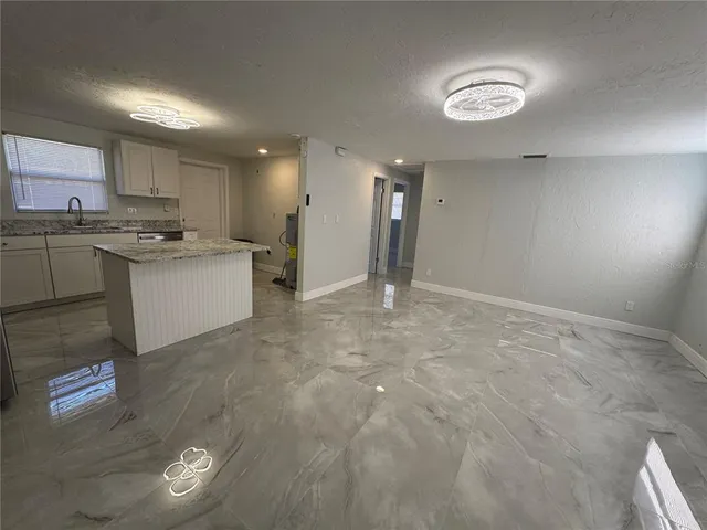 a kitchen with kitchen island a stove a sink and a refrigerator