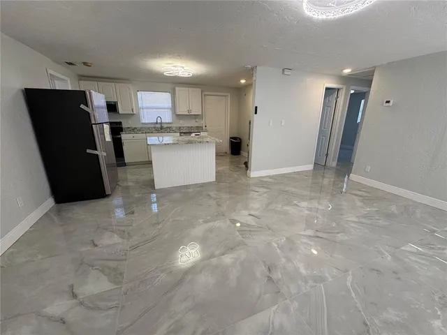 a view of kitchen with refrigerator stove and cabinets