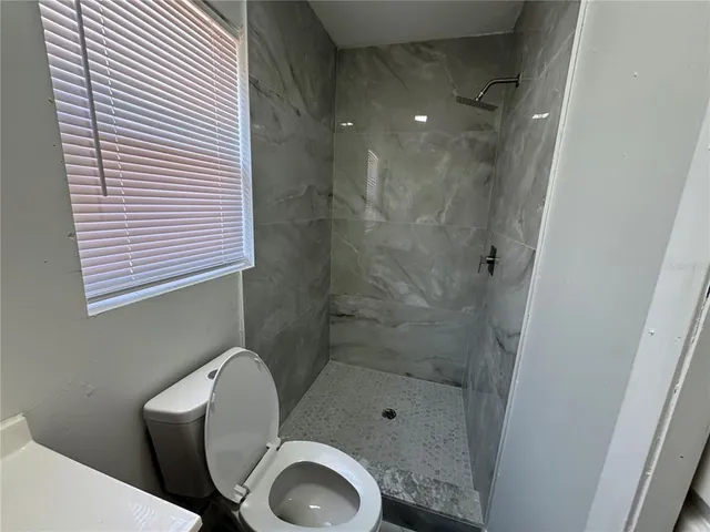 a bathroom with a toilet and a shower