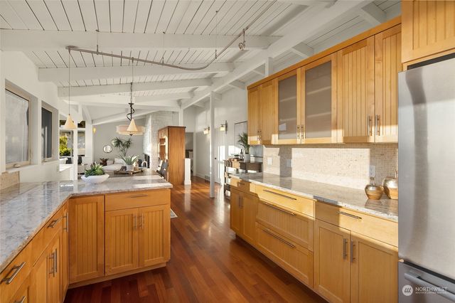 a kitchen with sink a refrigerator and wooden cabinets