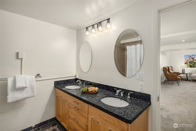 a bathroom with a granite countertop sink and a mirror
