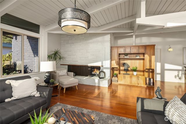 a living room with fireplace furniture and a large window