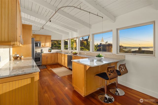 a kitchen with stainless steel appliances granite countertop a sink stove and wooden cabinets